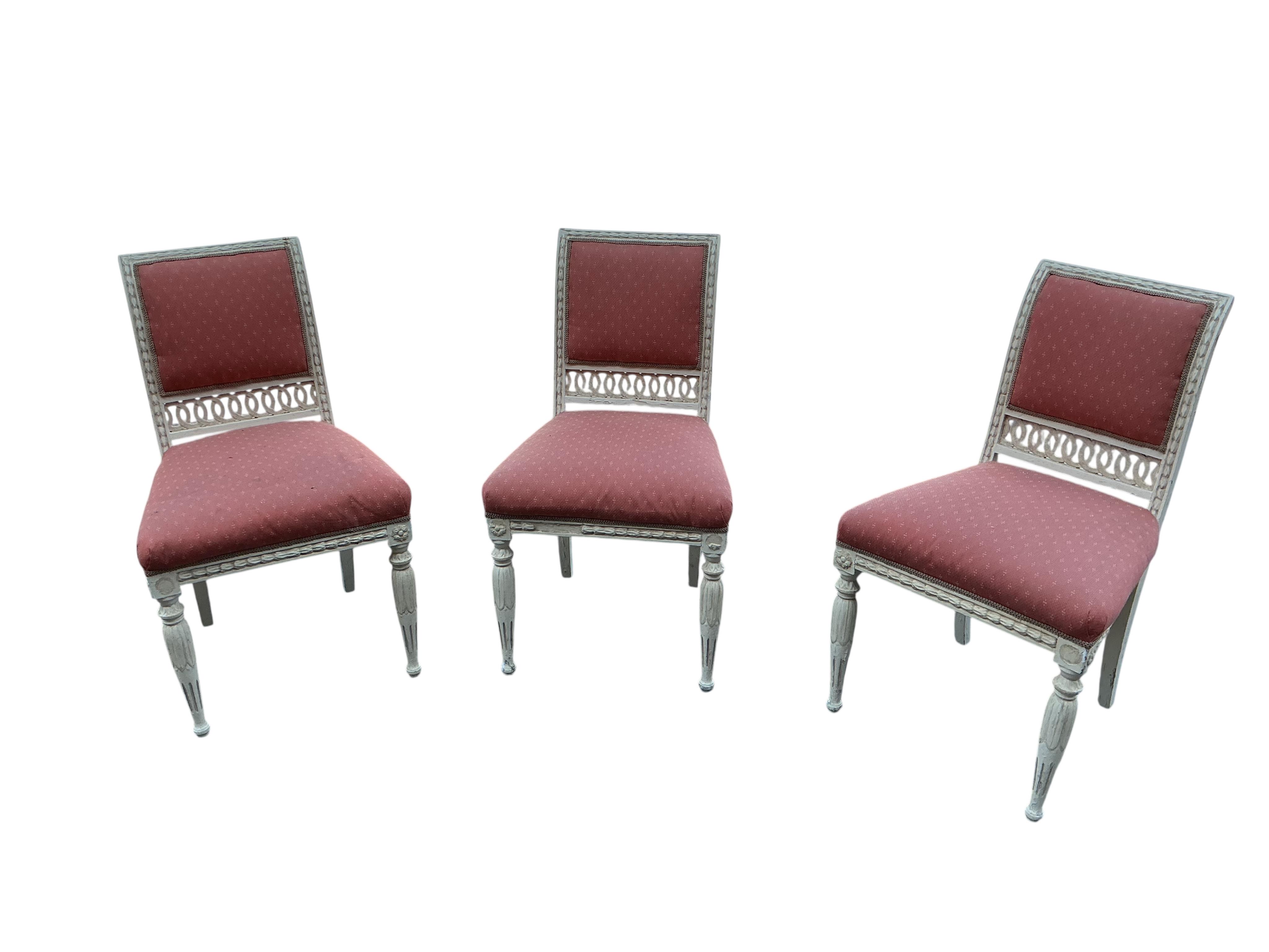 A harlequin set of six 20th century Louis XVI style white painted chairs with red upholstery